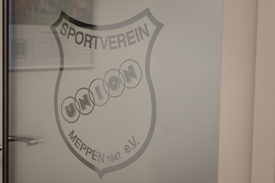 Auf frosted glass door is the logo of the sports club "Union Meppen 1947 e.V." clearly visible.