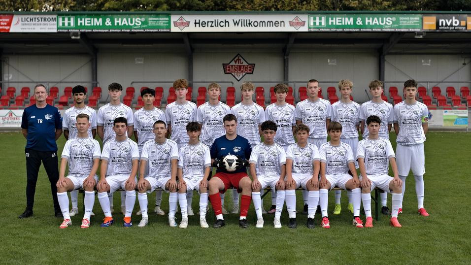 Mannschaftsfoto einer Jugendfu&szlig;ballmannschaft in wei&szlig;en Trikots auf dem Platz, umgeben von einer Trib&uuml;ne.